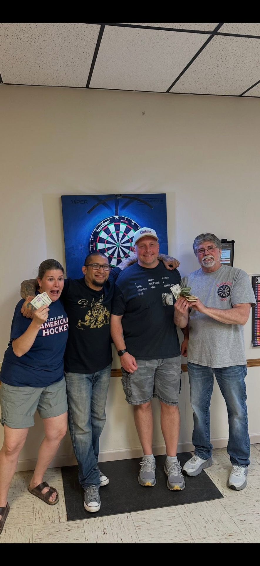 Championship participants Dion Harden and Bissy Macey pose alongside Steve and Alan in front of a dartboard